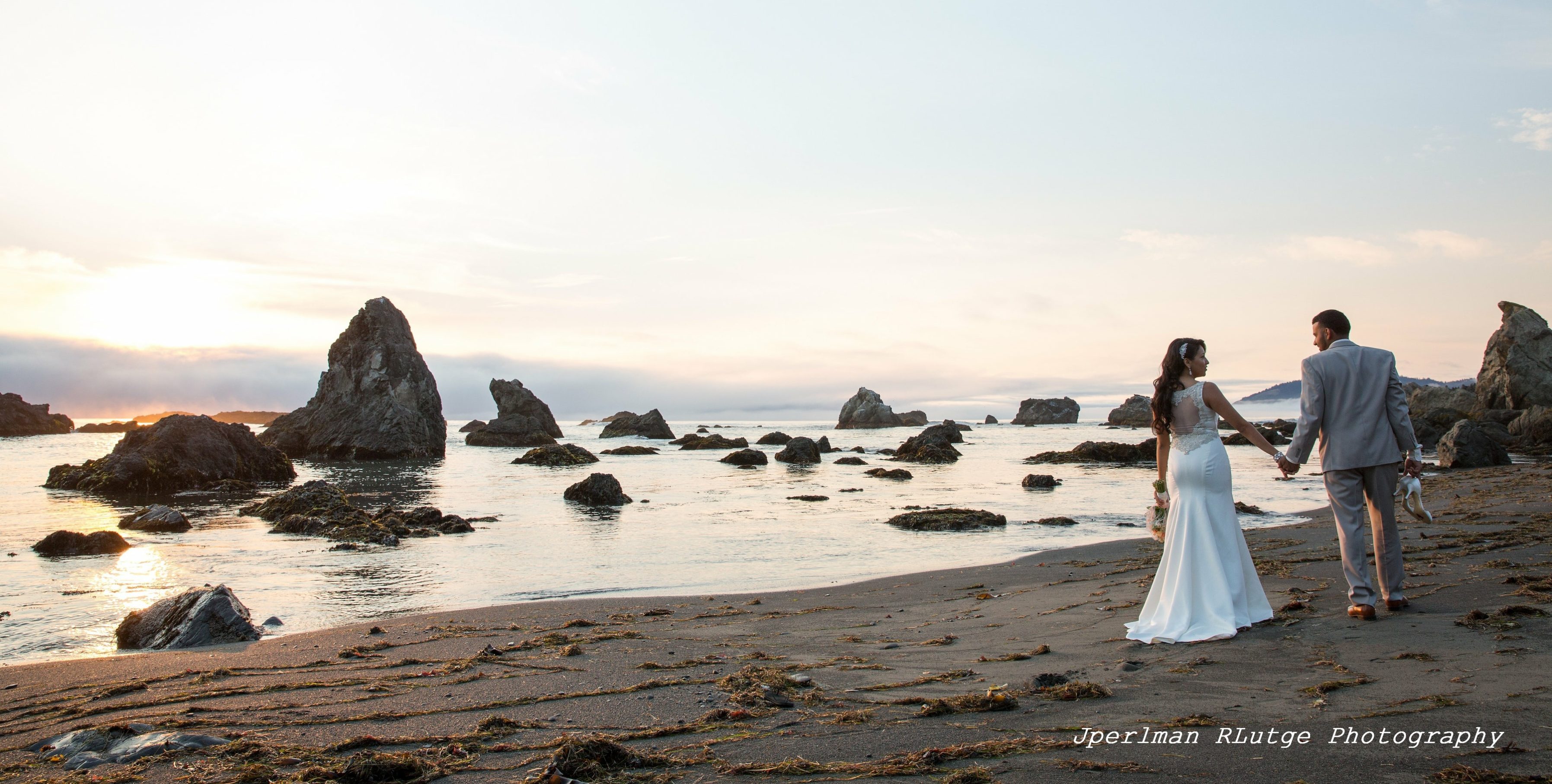 Johana and Isaac, after their Elope Mendocino wedding, stroll on the beach at Westport as the sun sets.